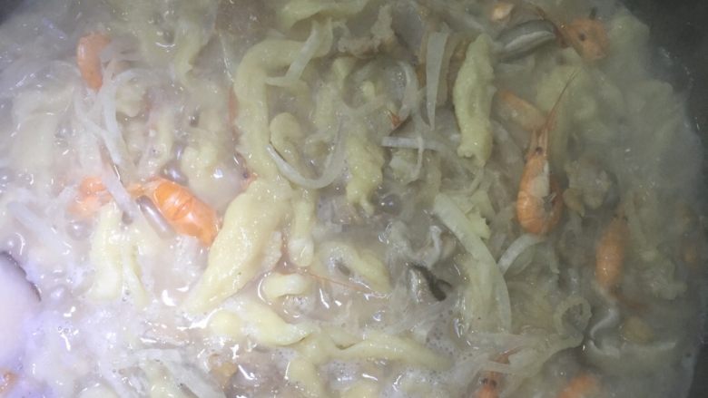 三鲜麦虾,烧开后把图3的面糊用刀划入锅中,一手拿刀一手拿碗,要一刀一刀划成细条,直到成条型烧熟