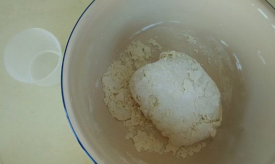 饺子,把絮状面粉揉起，还有些干面粉，这时把剩下的水倒入，继续揉面，边揉边搓面盆周围，使盆光