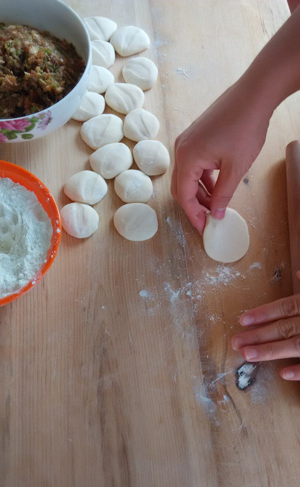 饺子,撒干面粉把切好的块按扁，开始擀面皮