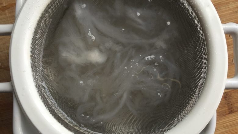 冰糖燕窝,放筛网中反复清洗,挑去燕绒毛。