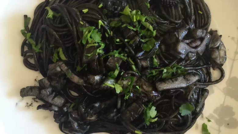 黑暗料理,意大利墨鱼面,煮好的人意大利面放入墨鱼锅中,相拌最后撒上香菜就可以了