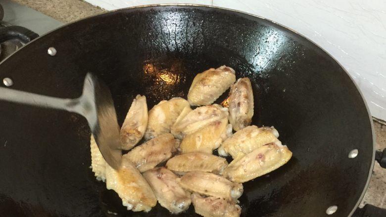 可乐鸡翅,热锅下油，然后下鸡翅，小火慢慢把鸡翅两面都煎成金黄色。