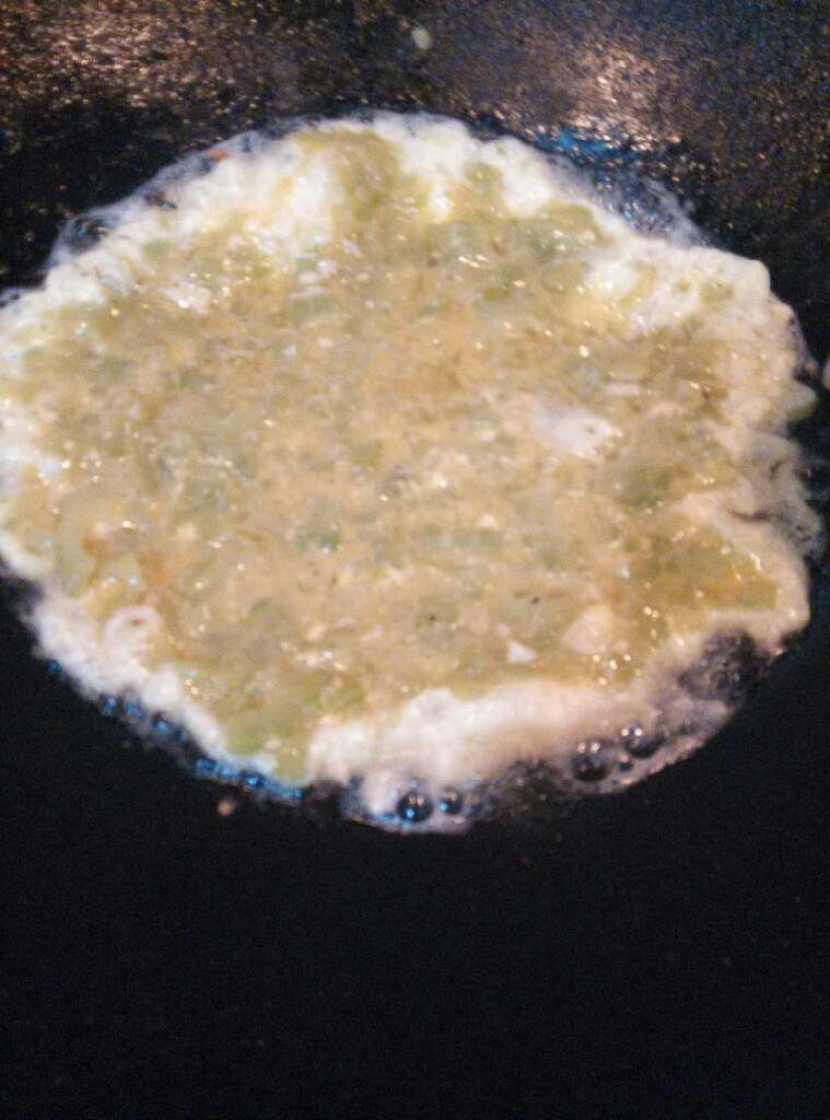 苦瓜鸡蛋饼#健康美颜餐#,锅里重新倒入点油,油温上来马上倒入苦瓜鸡蛋液,转中小火,慢慢煎成饼形,火太大容易烧焦