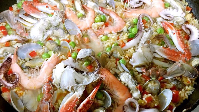 西班牙海鲜饭,小火大约20-30分钟看米饭成熟度,米饭好了就把准备好的海鲜摆好放入锅中,把海鲜往米里按压,继续闷,让米饭的味道也进入海鲜