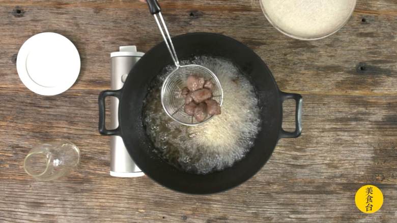 黑椒牛肉粒,油锅加热至六成热,牛肉粒炸至外层起壳后捞出