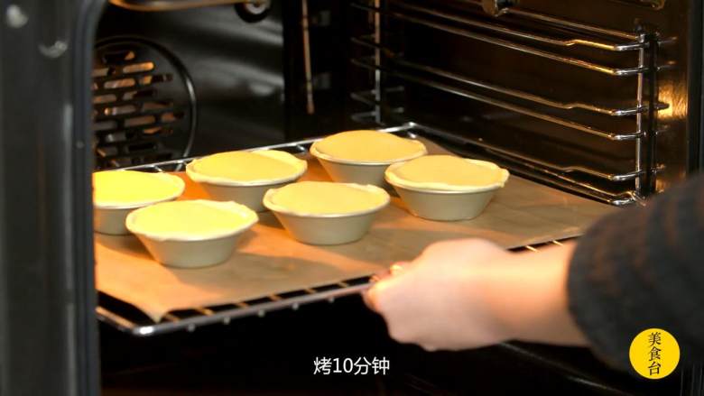 葡式蛋挞,烤箱预热250度，入中层烤十分钟，然后转至上层最高火烤五分钟上色，出炉后稍稍冷却，可撒少许豆蔻粉增香