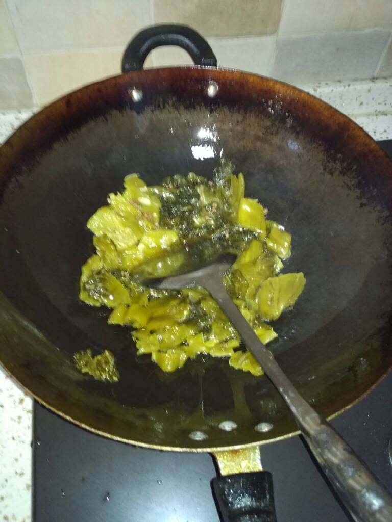 酸菜黄辣丁,锅中放油,待冒青烟时将酸菜,花椒放入锅中炒至酸菜泛白