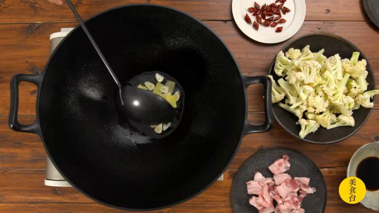 干锅花菜,热锅冷油,姜片、蒜片取一半倒入锅中爆香