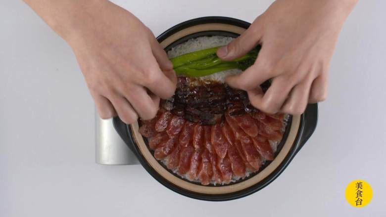 腊味煲仔饭,腊味切片，和烫熟的菜心铺在饭上