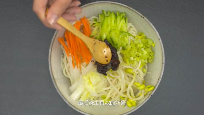 北京炸酱面,依次放上黄瓜丝、胡萝卜丝、白菜丝、豆芽、芹菜末，最后浇上炸酱，淋一点油汁完成。