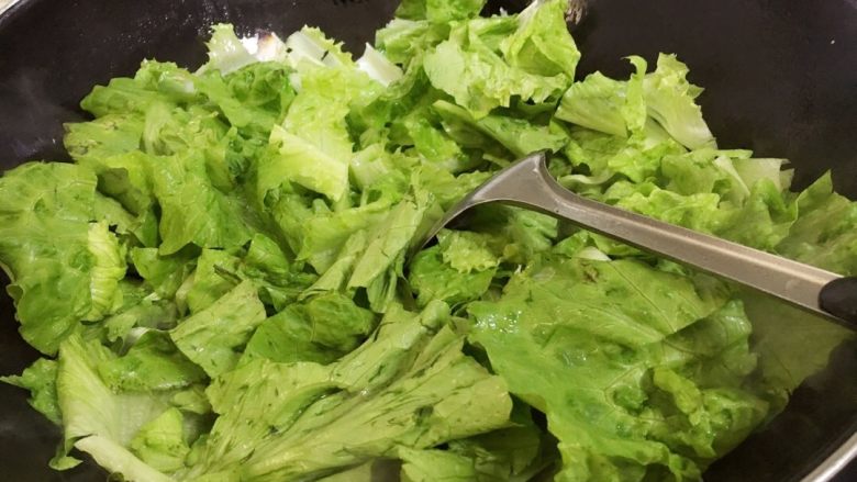 蚝油虾皮生菜#健康美颜餐#,锅里倒入适量食用油烧热,倒入蒜片炒香,再倒入生菜。