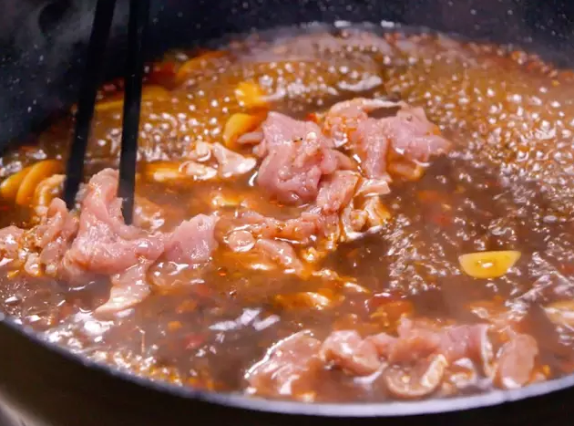 水煮肉片,烧到滚开，加一点<a style='color:red;display:inline-block;' href='/shicai/ 692'>酱油</a>。肉片抓散，下进沸腾的红汤锅里，等变色了，断火。加两勺<a style='color:red;display:inline-block;' href='/shicai/ 748'>花椒油</a>。