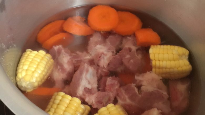 玉米萝卜汤,加水倒入高压锅中,人多水就加多,看人数定水量
