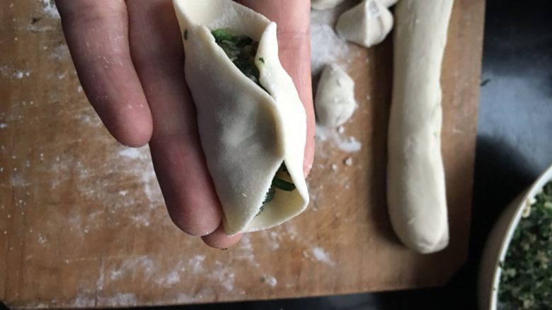 海螺荠菜饺,饺子皮加入馅后,先中间轻捏