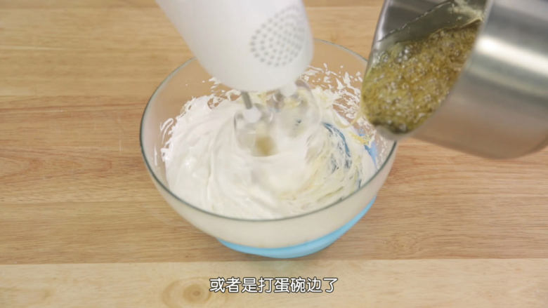 熬糖版牛轧糖,糖浆煮到140度之后关火,移出来,不要着急,接着把蛋白霜再次高速打发一下,因为刚才有一些结块了,搅打顺滑之后,糖浆慢慢加入蛋白霜中混匀,不要到太快,充分挥发水汽。糖浆全部加进去之后要持续搅打几十秒,直到感觉到有阻力,就表示打好了