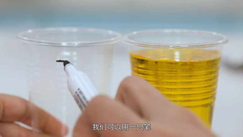 冰晶棒棒糖,糖水在放凉期间,我们准备好一个夹子,然后把粘了细砂糖的木棒夹在夹子中间,并且量好高度
