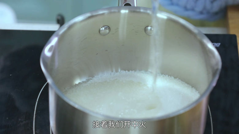 冰糖葫芦,我们在待会用来冷却糖葫芦的烤盘上面抹一层食用油防粘(什么油都可以,我用的是玉米油),接着来煮糖浆,把细砂糖和水加入厚底奶锅中,这样受热比较均匀,然后开中火把糖煮融化,融化之后转小火,直到把糖浆煮到我们要的状态,变成微微的黄色就可以了
