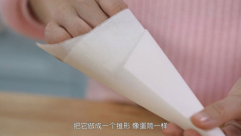 脆皮蛋筒和脆皮碗,脆皮机预热的时候我们来做一个辅助蛋筒成型的模具,那一张油纸叠成一个圆锥型