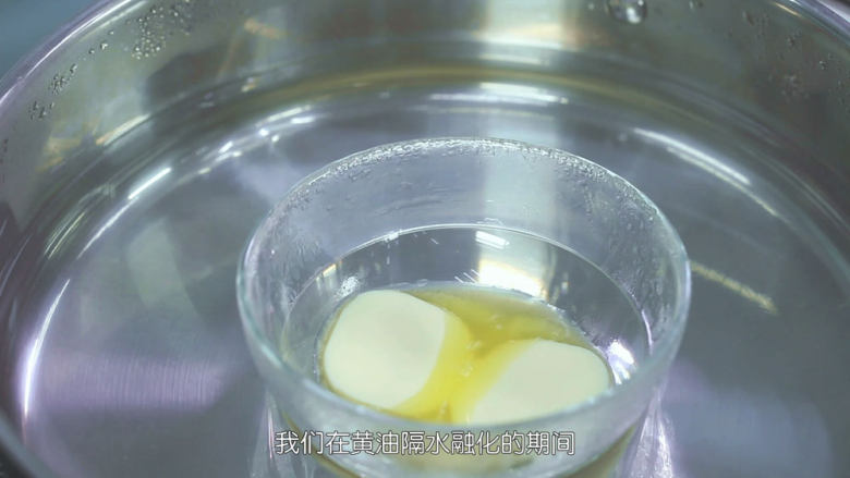烤蓝莓重芝士蛋糕,我们先来做饼干底的部分,首先烧开一锅热水然后关火,把无盐黄油放进去里面隔水加热融化成液体