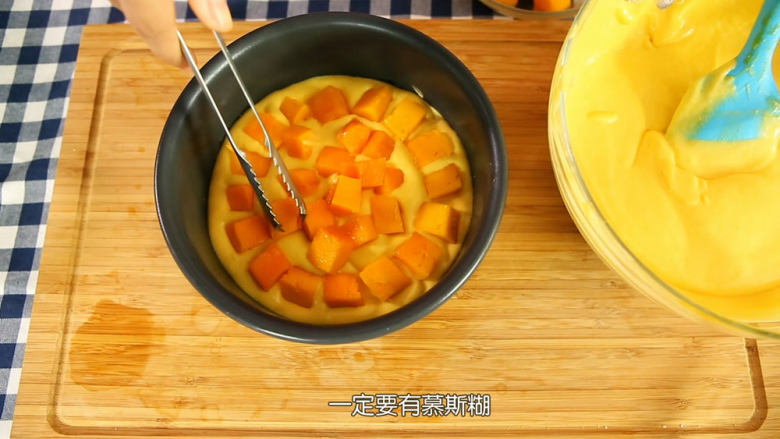 芒果流心慕斯,把冰箱里面的饼干底拿出来,倒入三分一的慕斯糊,铺上一层芒果肉,再倒一层慕斯糊,外围一圈铺上芒果果肉中间倒入芒果流心部分的芒果泥