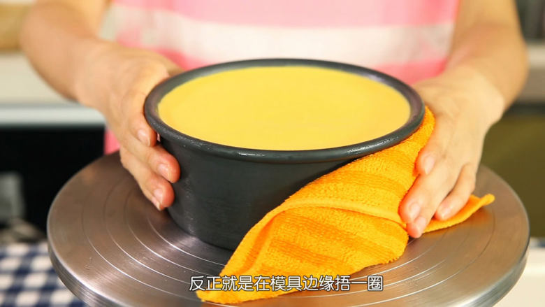 芒果流心慕斯,把已经冷藏好的芒果流心慕斯用热毛巾捂一下外围融化,方便脱模,撕开底部油纸,移到碟子上