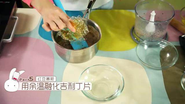 抹茶红豆卷,加入打碎的红豆,用刮刀搅拌均匀,直到红豆起沙,变成暗红色,再把已经泡软的吉利丁片放进去红豆糊里,用余温把吉利丁片融化