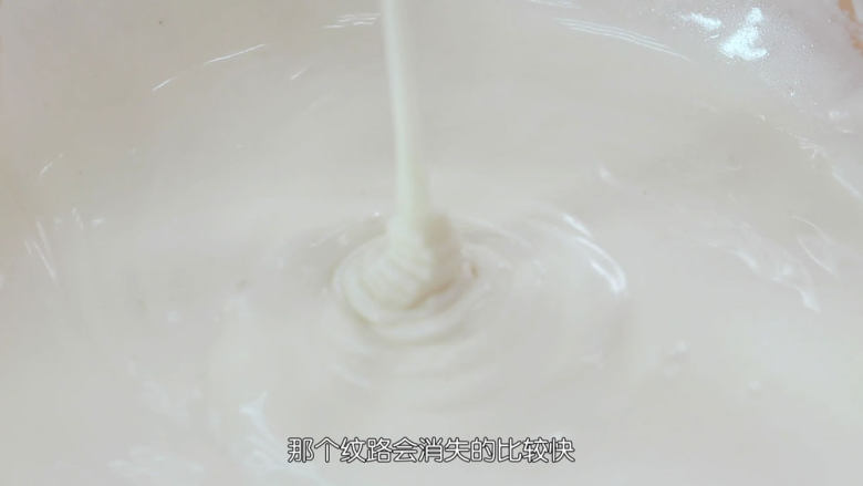 雪媚娘大福,接着要把水倒进去,配方中水的分量,是一个相对的量,为什么呢?因为不同牌子的糯米粉吸水性都不一样,那水的用量就会有多有少,我们要学会看面糊的状态,那我用的是三象牌的糯米粉,水量就是配方中的量175克,全部倒进去混匀,面糊提起来滴落会消失得比较快,这就是最佳的面糊状态了