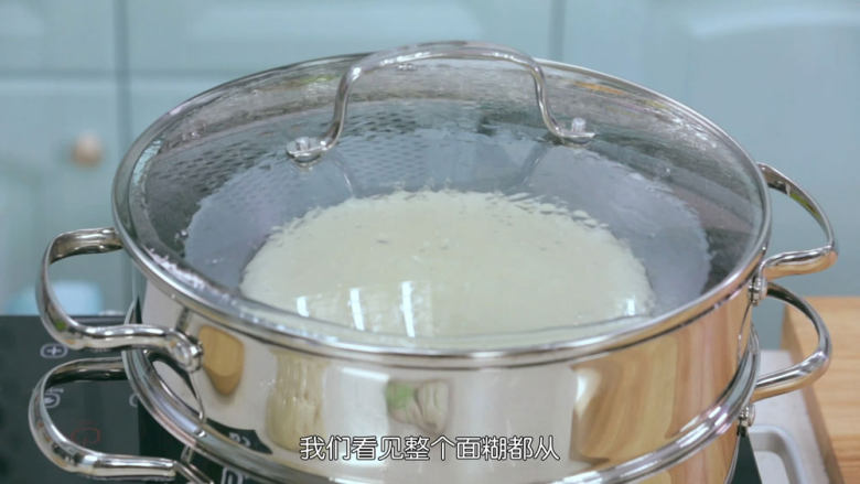 雪媚娘大福,面糊做好之后我们要把它倒入蒸碗里面,陶瓷碗受热会更加的均匀,然后把面糊拿去隔水蒸,面糊一定要在水沸腾之后再放进去蒸,并且大火蒸20分钟左右,蒸的时间也是不固定的,例如我的是电陶炉,你们家的是燃气炉,火力肯定不一样,那么时间也会有出入,我们看见整个面糊都从白色慢慢变成半透明状态的时候,就差不多了,可以去看看熟透了没有