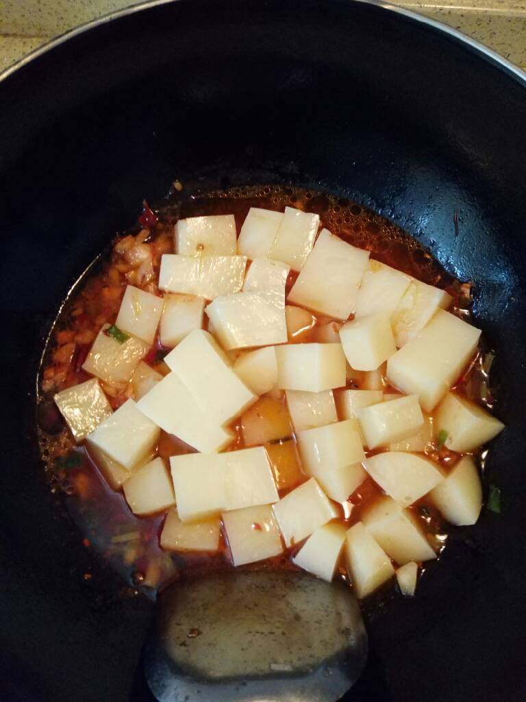 麻辣米豆腐,汤汁香味煮出,然后倒入米豆腐,加入适量的料酒,酱油,白糖,少许的盐,开中火慢炖