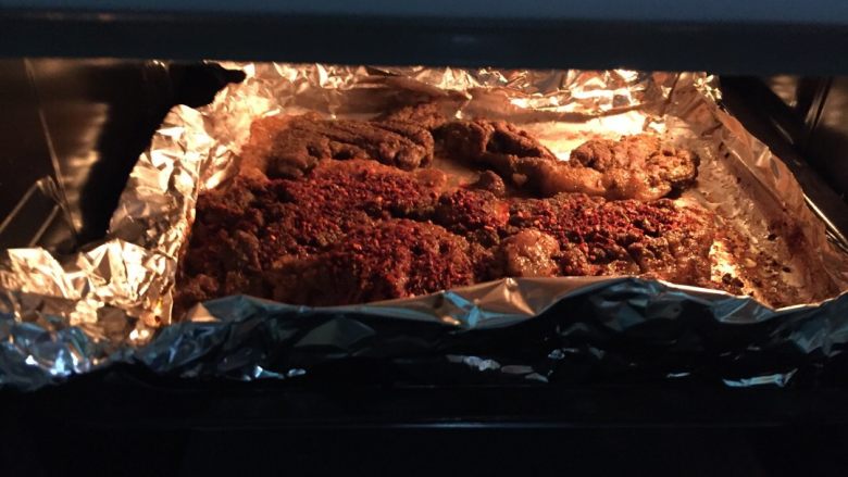 烤羊腿肉,三十分钟后打开锡纸,如有锡纸内肉汁较多可倒掉,均匀撒香辣椒面,不吃辣可不放,继续打开锡纸烤20分钟温度不变