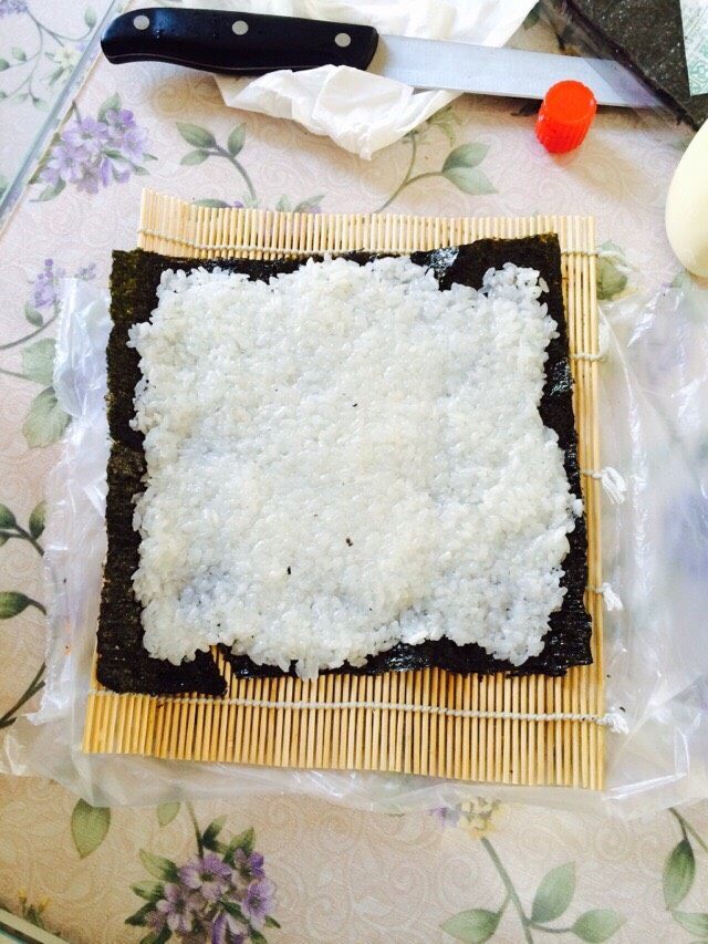 紫菜包饭,将米饭均匀摊铺在<a style='color:red;display:inline-block;' href='/shicai/ 279'>海苔</a>上，在中间放黄瓜，火腿或萝卜…