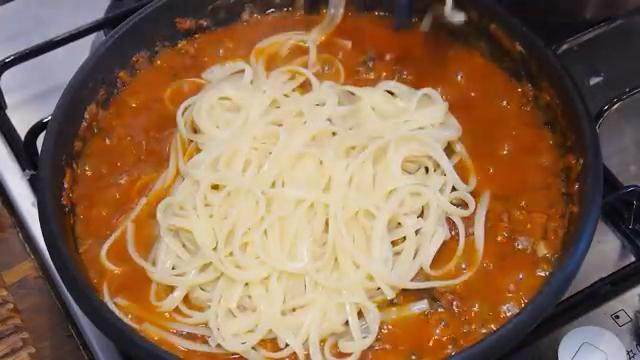 番茄肉酱意面,放入面条翻拌,等酱汁收汁即可装盘,放上罗勒叶装饰