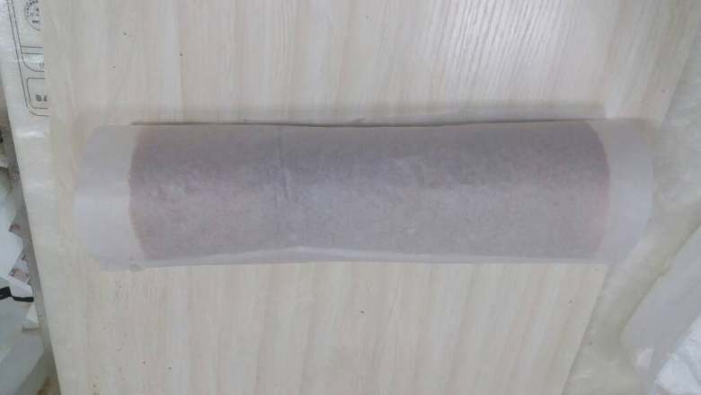 奶油草莓蛋糕卷,从有草莓的一端卷起,卷好的蛋糕卷用油纸包起后冷藏定型。