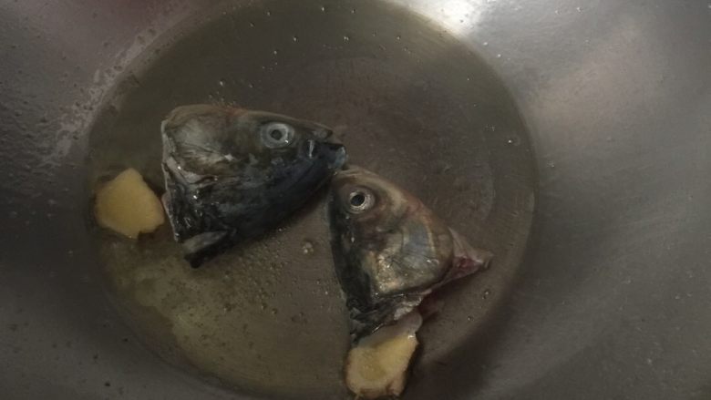 糖醋鱼片汤,热锅冷油,下生姜、鱼头,煎鱼头至半熟,下开水
