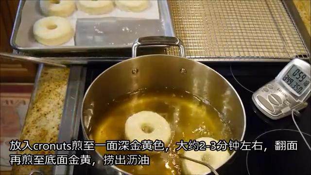 冬日完美安抚美食—可颂甜甜圈(完全手工版),将油纸裁开,把植物油加热到175摄氏度,放入甜甜圈将两面煎至金黄,捞出沥油