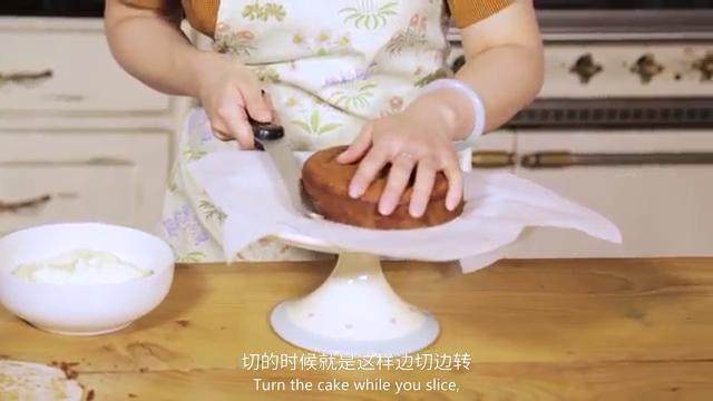 胡萝卜蛋糕,在蛋糕盘上垫一张纸,放上蛋糕,横向切一半