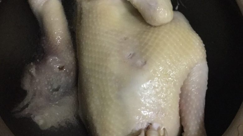 葱油鸡,熟了的鸡捞出马上放到冰水泡,令鸡肉快速收缩,泡五六分钟左右,注:冰水先准备好,我是用另外一个锅装好干净的水,先放冰箱里备用。