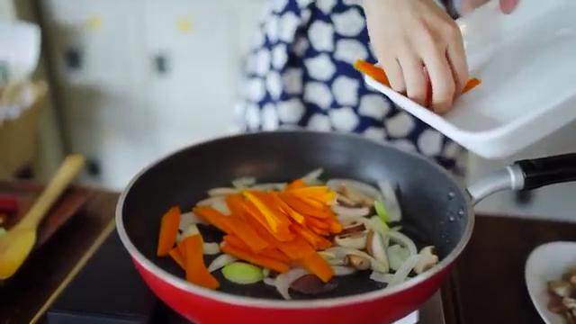 猪肉炒乌冬,放入洋葱和香菇炒香，倒入胡萝卜翻炒