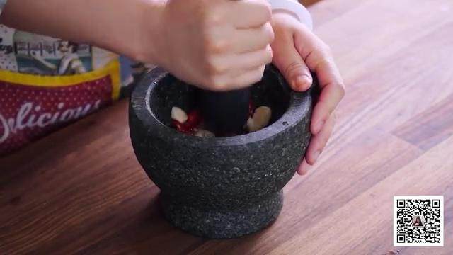 牛排沙拉,把切好的棕榈糖、朝天椒、蒜头放入石臼中,挤出青柠汁,捣碎研磨成泥状