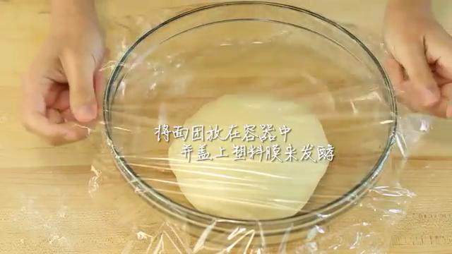 牛奶红豆饼,将揉好的面团放到容器中，盖上塑料膜，发酵至面团两倍大