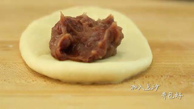 牛奶红豆饼,将面团擀成椭圆形，放入豆沙，包好。