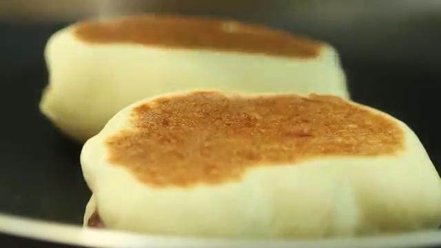 牛奶红豆饼,不粘锅小火加热后，放入红豆饼，盖上盖子，至金黄色后翻面，直到两面金黄色，里面熟为止。喜欢表面脆些的可以煎时间长些，软的煎时间短些。