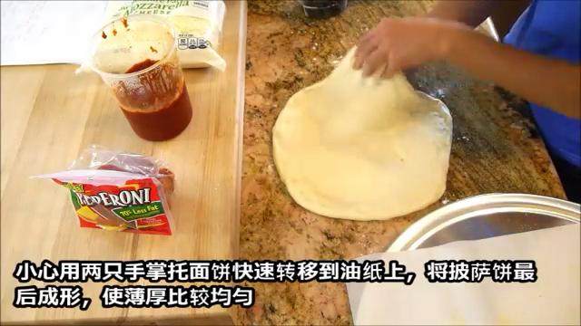 史上最快速简单好吃的披萨完全手工版,烤盘上放油纸,撒玉米粉。面团按成20cm左右圆饼,边缘向外抻成直径11寸左右的圆饼,在放到烤盘上