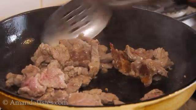 羊肉抓饭,热锅倒油，放入羊肉翻炒至变色出油，捞出待用