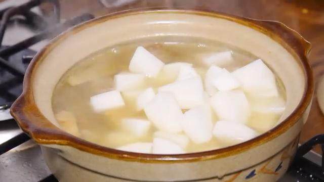 鲜虾羊肉砂锅,捞出葱段，放入白萝卜，大火煮开转小火煮半小时