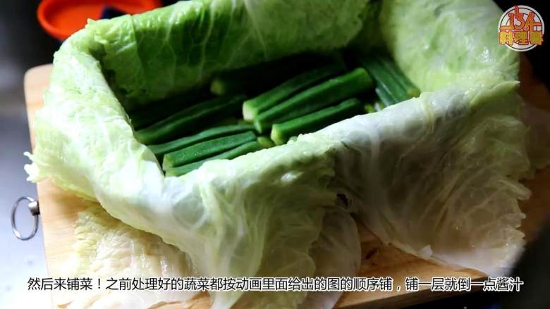 九珍蔬菜法式冻,容器里铺一层保鲜膜,铺上包菜叶,叶子要铺出来一些,一次放入一层芦笋、秋葵、花菜、胡萝卜条、玉米笋、黄瓜、西葫芦,注意一层蔬菜就要倒一层酱汁
