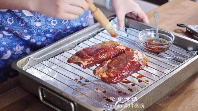 蜜汁叉烧,把肉放在烤架上，烤箱预热200度，把酱汁、蜂蜜、油混合刷在肉上