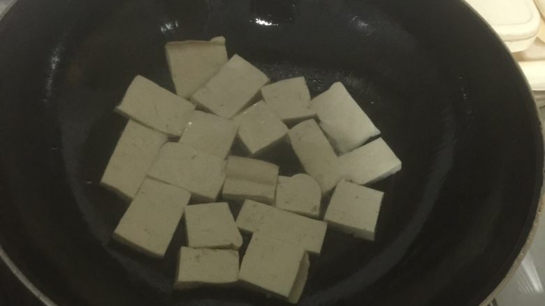 香辣豆腐烩豆角,放适量油，待油热后放入切好的豆腐，煎至两面金黄