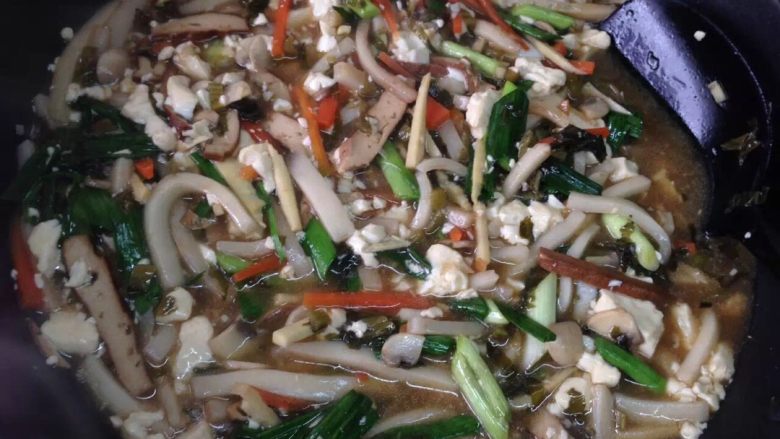 嵊州特色炒年糕,待蘑菇胡萝卜出水后，加入年糕继续翻炒，放两茶匙<a style='color:red;display:inline-block;' href='/shicai/ 788'>生抽</a>、少许<a style='color:red;display:inline-block;' href='/shicai/ 10588'>糖</a>、适量盐。炒入味后，放入<a style='color:red;display:inline-block;' href='/shicai/ 465'>豆腐</a>，加水炖煮。