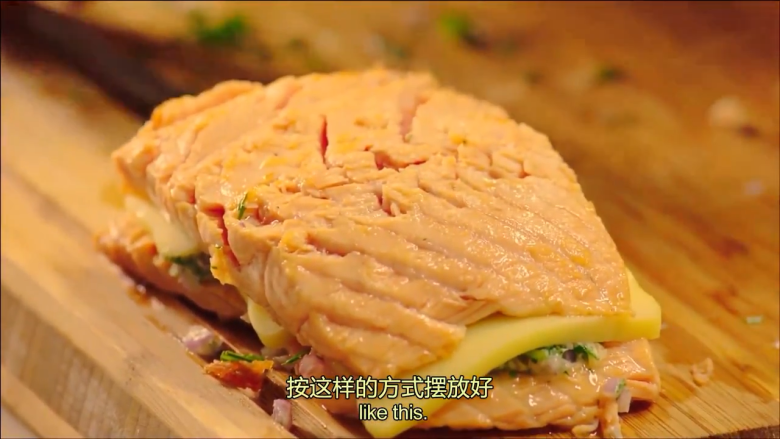 起酥三文鱼派,把黄油混合物,马苏里拉奶酪,罗勒叶放在鱼肉上,用另外一块鱼肉盖在上边
